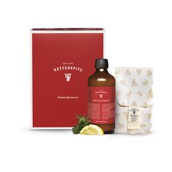 Rote Box mit Flasche, Zitrone und Kräutern auf hellem Hintergrund.
